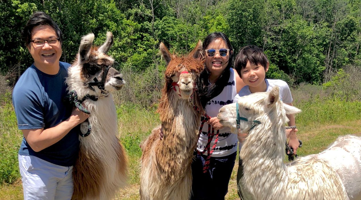 A family poses with alpacas at Clover Brook Farm, Hyde Park